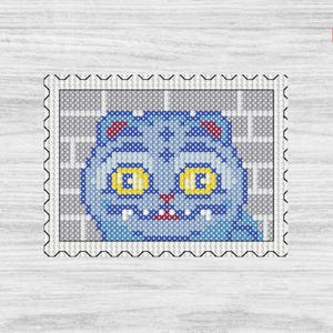 May include: A cross-stitch design of a blue cat on a postage stamp. The cat has yellow eyes, red ears, and a small mouth. The background is a gray brick pattern. The stamp has a perforated edge.