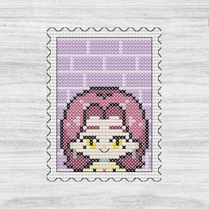 Op de afbeelding: Kruissteekontwerp van een stripfiguur op een postzegel. Het personage heeft roze haar en gele ogen, tegen een lichtpaarse bakstenen achtergrond. De postzegel heeft een witte rand met een geperforeerde rand.