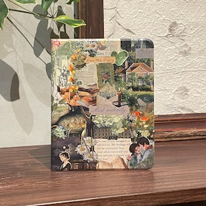 Könnte beinhalten: Ein dekoratives Notizbuch mit einem Collage-Design mit floralen Elementen, Vintage-Bildern und Text. Das Cover des Journals enthält die Sätze "Dear Mr. Darcy" und "Most ardently."