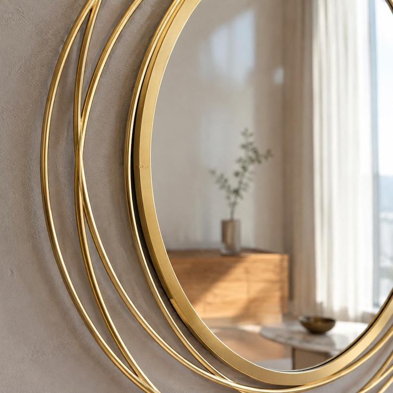 Peut inclure: Un miroir mural circulaire dot&eacute; d'un cadre en m&eacute;tal dor&eacute; poli. Le cadre est compos&eacute; de plusieurs anneaux fins, concentriques et superpos&eacute;s, cr&eacute;ant un effet g&eacute;om&eacute;trique en couches autour de la surface centrale en verre r&eacute;fl&eacute;chissant.