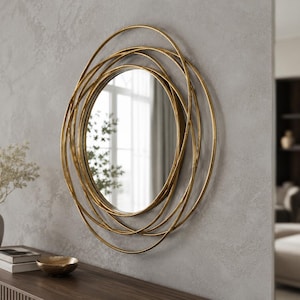 Peut inclure: Un miroir mural circulaire doté d'un cadre composé de plusieurs anneaux métalliques dorés superposés de tailles variées. La glace centrale est ronde et reflète un intérieur lumineux avec une fenêtre et de la verdure, créant un effet géométrique.
