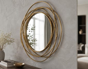 Peut inclure: Un miroir mural circulaire doté d'un cadre composé de plusieurs anneaux métalliques dorés superposés de tailles variées. La glace centrale est ronde et reflète un intérieur lumineux avec une fenêtre et de la verdure, créant un effet géométrique.