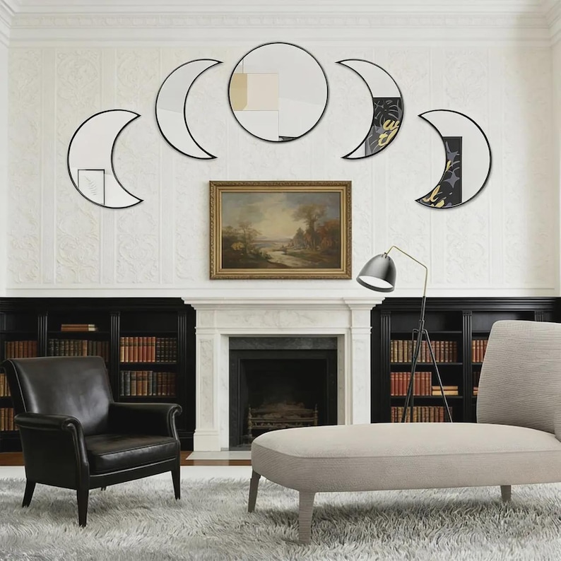 May include: A set of five wall-mounted mirrors arranged in a horizontal lunar phase sequence. The collection includes one central circular mirror flanked by four crescent-shaped mirrors, all featuring thin black frames and reflective glass surfaces.