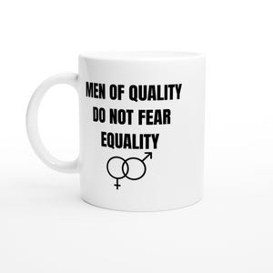 Könnte beinhalten: Ein weißer Keramikbecher mit dem in Schwarz aufgedruckten Text MEN OF QUALITY DO NOT FEAR EQUALITY. Unter dem Text befindet sich ein schwarzes grafisches Symbol, das die weiblichen und männlichen Geschlechtszeichen kombiniert und mittig verknüpft.