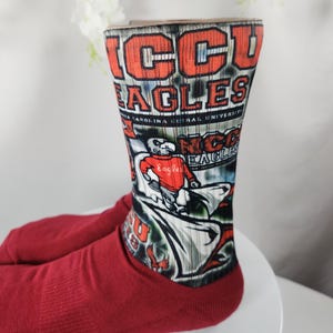 May include: Maroon socks with the text "NCCU EAGLES" in red and white. The socks feature a graphic of an eagle and the words "North Carolina Central University".