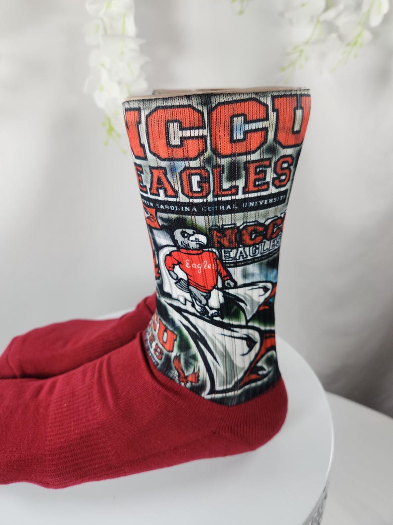 May include: Maroon socks with the text "NCCU EAGLES" in red and white. The socks feature a graphic of an eagle and the words "North Carolina Central University".