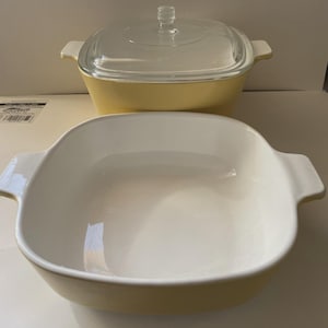 May include: Two-piece yellow and white casserole dish set. The bottom dish is square with a white interior and yellow exterior. The top dish has a clear glass lid and a yellow exterior. Both dishes have handles.