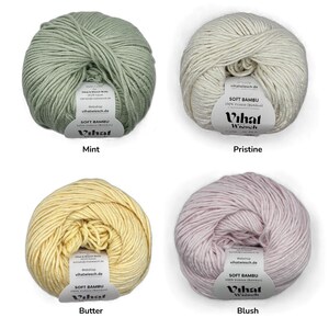 Puede incluir: Cuatro ovillos de hilo Soft Bambu en colores menta, pr&iacute;stino, mantequilla y rubor. Cada ovillo tiene una etiqueta de papel blanco con el texto Vihat Wiesch, Soft Bambu y 100% Viskose (Bamboo). El hilo tiene una textura suave y retorcida.