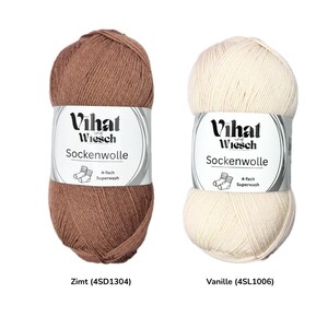 May include: Two skeins of Vihat Sockenwolle yarn. One is a warm brown, the other is off-white. Each skein has a label with the brand name, yarn type, and a graphic of socks. The brown yarn is labeled "Zimt", and the off-white yarn is labeled "Vanille".