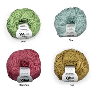 Puede incluir: Cuatro ovillos de hilo Soft Bambu en verde hoja, azul cielo, rosa flamenco y bronceado. Cada ovillo tiene una etiqueta de papel blanco con el texto Vihat Wiesch, 100% Viskose (Bambus) y vihatwiesch.de. El hilo tiene una textura lisa y retorcida.