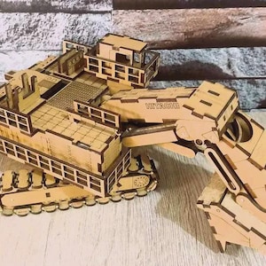 Op de afbeelding: Een houten model van een Hitachi graafmachine. Het model is gemaakt van lichtbruin hout en heeft ingewikkelde details, waaronder de graafarm, rupsbanden en cabine. Het woord "HITACHI" is zichtbaar.