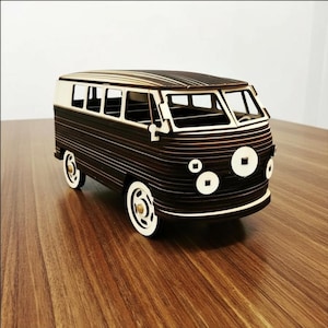 Könnte beinhalten: Ein Holzmodell eines klassischen Vans, mit einem dunkelbraunen Korpus und weißen Akzenten. Der Van hat weiße Räder und Fenster und steht auf einer Holzoberfläche. Ein detailliertes Modell.