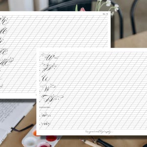 Puede incluir: Dos hojas de pr&aacute;ctica de caligraf&iacute;a con l&iacute;neas de cuadr&iacute;cula diagonales. La hoja izquierda muestra las letras min&uacute;sculas M, y la hoja derecha muestra las letras min&uacute;sculas W. Las hojas son blancas con letras y l&iacute;neas de cuadr&iacute;cula negras. El texto "thegoodcalligraphy" est&aacute; en la esquina inferior derecha.