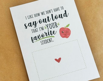 May include: A white card with a red apple illustration and the text "I like how we don't have to say out loud that I'm your favorite student."