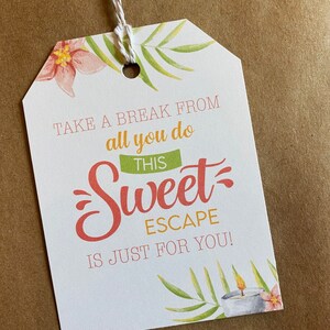 May include: White gift tag with green and pink floral illustrations. The text reads "Take a break from all you do this Sweet Escape is just for you!"