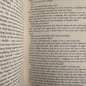 May include: An open book displaying text from C.S. Lewis's novel, Perelandra. The pages are aged, with black text. The book is open, revealing multiple paragraphs of printed text.