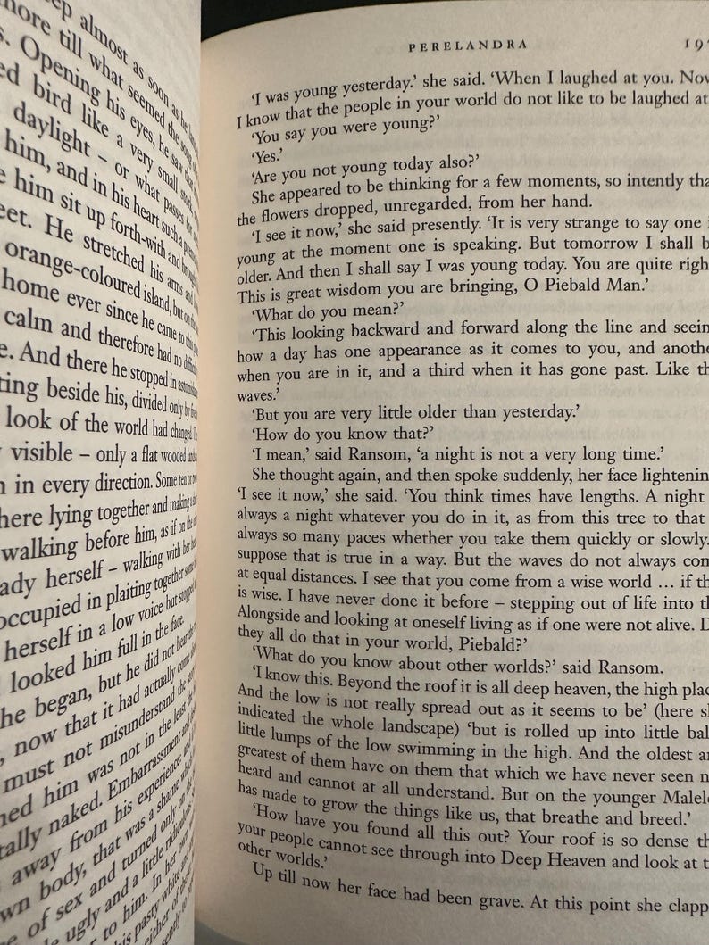 May include: An open book displaying text from C.S. Lewis's novel, Perelandra. The pages are aged, with black text. The book is open, revealing multiple paragraphs of printed text.