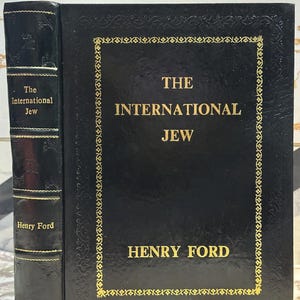 May include: A hardcover book titled "The International Jew" by Henry Ford. The book has a black cover with gold lettering and a decorative gold border. The spine also features the title and author.