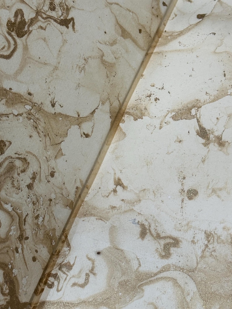 May include: Abstract artwork featuring a marbled design in shades of cream and brown. The pattern has a fluid, organic appearance with swirling textures and subtle color variations. The artwork is divided by a thin, light-colored line.