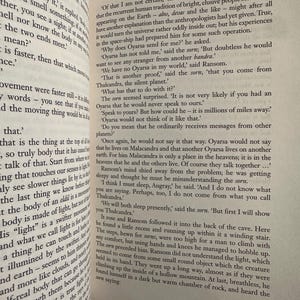 May include: An open book displaying text from C.S. Lewis's "Out of the Silent Planet". The pages are aged, with black text. The book is open to a page with the number 87 in the top right corner.