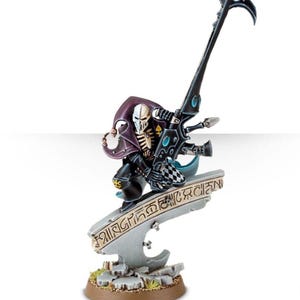 May include: Miniature figure of a Harlequin, a character from Warhammer 40,000. The figure is painted in black, white, and purple, with a stylized skull mask. It is posed on a gray platform with engraved text, holding a large, ornate weapon.