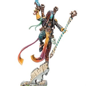 May include: A miniature figurine of a character in a black and checkered outfit, holding a staff and a weapon. The figure has a harlequin-style hood and is posed on a stone base. The color palette includes black, red, yellow, and blue.