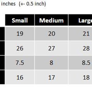 Op de afbeelding: Een zwart-wit tabel toont kledingmaten in inches. De tabel bevat borst-, lichaamslengte-, mouwlengte- en schouderafmetingen voor de maten small, medium, large en extra large. De tekst bovenaan luidt: "Alle afmetingen zijn in inches (+-0,5 inch)".
