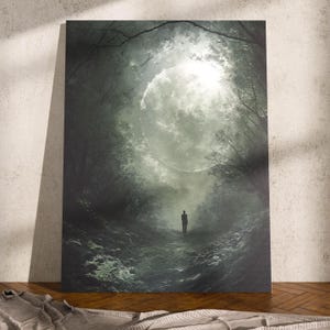 May include: A canvas print showing a surreal forest scene. A solitary figure walks along a path towards a bright, glowing moon. The artwork is rendered in shades of green and grey, creating a mysterious and atmospheric feel.