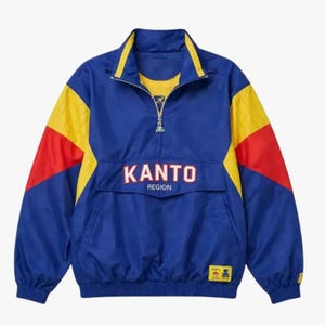 May include: A blue pullover windbreaker jacket featuring a quarter-zip collar with yellow trim. The sleeves have yellow and red color-blocked panels. The front displays the text KANTO REGION in white letters with a red outline above a pocket flap.