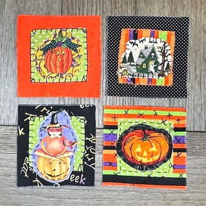 May include: Four square fabric patches featuring Halloween themes. One shows a pumpkin on green polka dots with an orange border. Another depicts a house with bats on striped fabric. A third shows a witch on a pumpkin. The fourth features a large jack-o'-lantern on striped fabric.