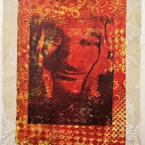 May include: A mixed media artwork featuring a portrait in shades of red and brown. The portrait is framed by a textured, patterned border in yellow and orange, set against a neutral background with a subtle floral design.