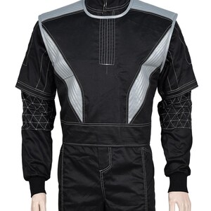 May include: Black racing suit with silver accents. The suit features a high collar, long sleeves, and a tailored fit. Silver panels are stitched on the chest and shoulders. White stitching details the seams and geometric patterns on the sleeves.