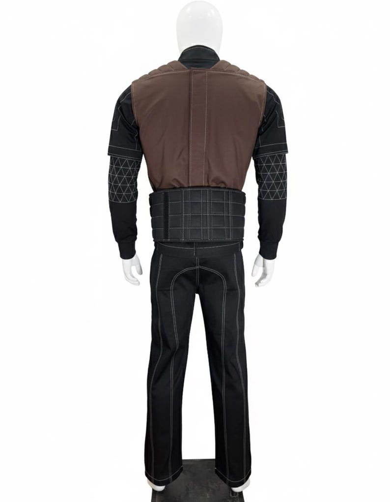 Puede incluir: Un disfraz completo exhibido en un maniqu&iacute;. El atuendo incluye pantalones negros con costuras blancas, una camisa negra de manga larga, un chaleco marr&oacute;n y un cintur&oacute;n negro. El chaleco y el cintur&oacute;n tienen costuras blancas.
