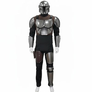 May include: A Mandalorian armour costume. It includes a silver helmet, chest plate, shoulder pads, and arm guards. The outfit features a brown and black torso piece, black trousers, and leg armour. A holster is attached to the trousers.