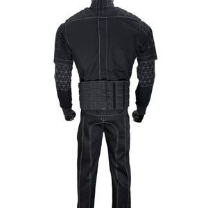 Puede incluir: Traje t&aacute;ctico negro exhibido en un maniqu&iacute;. El traje presenta costuras blancas que delinean las costuras y patrones geom&eacute;tricos en las mangas. El conjunto incluye una chaqueta, pantalones y un componente similar a un cintur&oacute;n en la cintura. El maniqu&iacute; tiene una cabeza negra.