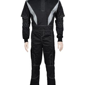 May include: Black racing suit with silver accents. The suit features a high collar, a front zipper, and white stitching details. The shoulders and upper chest have silver panels. The sleeves have a geometric design near the cuffs. The pants have reinforced knee panels.