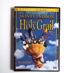 May include: A DVD case for "Monty Python and the Holy Grail" featuring a blue background with a castle and characters. The title is in gold lettering, and the case is labeled "Special Edition."