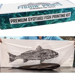 May include: A fish printing kit with a box that reads "Fishin' Prints Remember the Catch" and "Premium Gyotaku Fish Printing Kit." A white cloth displays a black and white fish print, with a real fish below.
