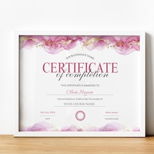 Puede incluir: Certificado de finalización enmarcado con borde blanco. El certificado tiene un diseño de acuarela en tonos rosa y dorado. El texto dice "CERTIFICATE of completion" e incluye campos para el nombre del destinatario, el nombre del curso, la fecha y el nombre del instructor.