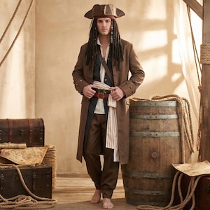 May include: A brown pirate costume featuring a long coat, pants, and a tricorn hat. The outfit includes a white shirt, a striped sash, and a red belt. The costume is designed to resemble a classic pirate look.