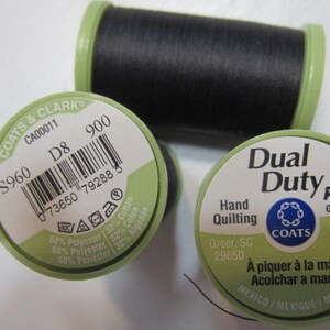 May include: Three spools of black thread with green labels. Two spools have the text "COATS & CLARK" and "Dual Duty Plus". One spool has 325 yds of thread, the other has 297 m.