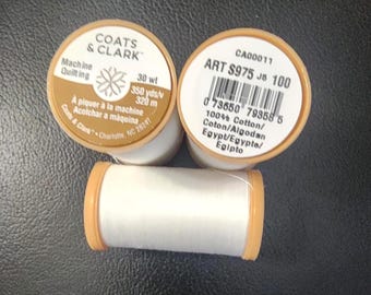 May include: Three spools of white Coats & Clark machine quilting thread. The spools have tan-colored tops and bottoms. The labels include text such as "30 wt" and "350 yds/320 m".