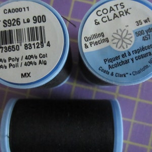 May include: Three spools of black thread with blue and white labels. The labels include the brand name "Coats & Clark", the thread weight, and the yardage. One label also includes the thread composition: 60% polyester and 40% cotton.