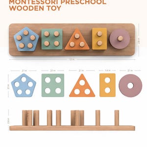 Può includere: Giocattolo in legno Montessori per la scuola materna. Una base in legno con cinque forme geometriche colorate: un pentagono blu, un quadrato verde, un triangolo arancione, un rettangolo giallo e un cerchio rosa. La base è lunga 30,5 cm e alta 7,1 cm.