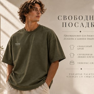 以下が含まれることがあります： クルーネックのオリーブグリーンの半袖Tシャツで、胸元に小さな白いロゴが入っています。右側のテキストは「СВОБОДНАЯ ПОСАДКА」、「Пространство для движения. Лёгкость в каждом движении.」、「СВОБОДНЫЙ КРОЙ」、「СПУЩЕННАЯ ЛИНИЯ ПЛЕЧА」、「УНИСЕКС-СИЛУЭТ」、「PARADISE PALETTE ОДЕЖДА СО СМЫСЛОМ」と書かれています。