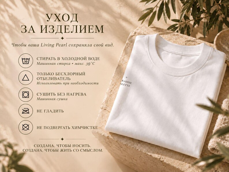 以下が含まれることがあります： 袖にPARADISE PALETTEの文字がプリントされた、折りたたまれた白いTシャツ。画像にはロシア語のケアラベルが含まれており、30度以下の冷水での洗濯、非塩素系漂白剤の使用、熱を避けた乾燥、アイロン掛け禁止、ドライクリーニング禁止を示すアイコンが表示されています。