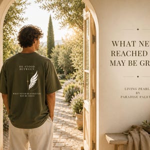 以下が含まれることがあります： オリーブグリーンのTシャツには、白い翼のグラフィックと「HE STOOD BETWEEN WHAT NEVER REACHED YOU MAY BE GRACE」という文字がプリントされています。Tシャツは明るい色のズボンと合わせて着用されており、壁には「WHAT NEVER REACHED YOU MAY BE GRACE. LIVING PEARLS BY PARADISE PALETTE」という文字が書かれています。