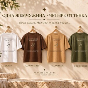 以下が含まれることがあります： 白、茶色、ベージュ、オリーブグリーンの半袖Tシャツ4枚。それぞれ中央にキリル文字のテキストと葉のイラストが描かれています。Tシャツは木製のハンガーに掛けられ、上部にテキストが書かれた明るい色の壁の前に並んでいます。