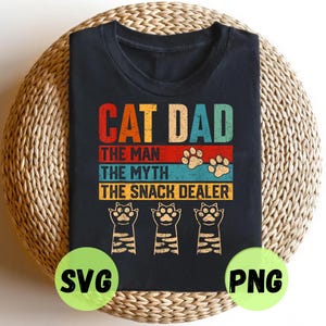 Puede incluir: Una camiseta negra de manga corta con un gráfico de estilo vintage con el texto CAT DAD, THE MAN, THE MYTH, THE SNACK DEALER en rojo, beige y azul. El diseño incluye dos huellas y tres patas de gato con patrones de rayas.