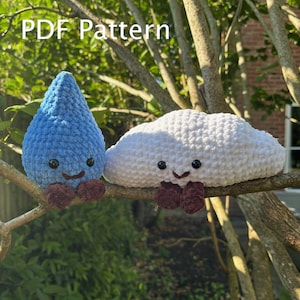 Könnte beinhalten: Ein blauer Häkel-Regentropfen und eine weiße Häkel-Wolke mit lächelnden Gesichtern und weinroten Füßen, auf einem Ast sitzend. Der Text "PDF Pattern" befindet sich in der oberen linken Ecke. Diese handgefertigten Amigurumi sind skurril und dekorativ.